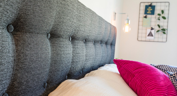 luxury buttoned headboard in charcoal attached to bed