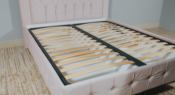 pink upholstered bed frame with slatted base without mattress