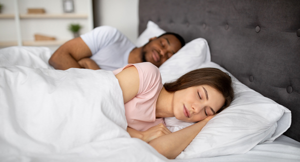 young couple sleeping together in bed